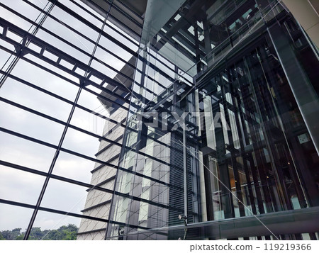 A modern tall building that features a significant amount of glass A modern tall building that features a significant amount of glass 119219366