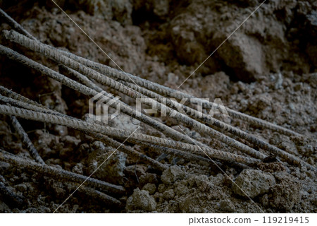 Large pile of earth in which there are many metal reinforcement bars Large pile of earth in which there are many metal reinforcement bars 119219415