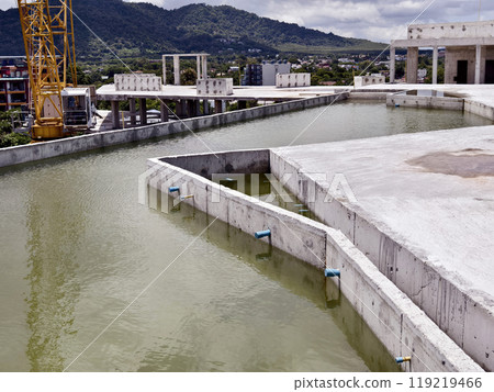Large building with a roof pool of water under construction 119219466