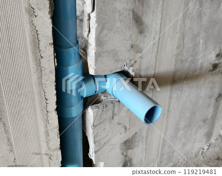 A bright blue pipes attached to a solid concrete wall A bright blue pipes attached to a solid concrete wall 119219481
