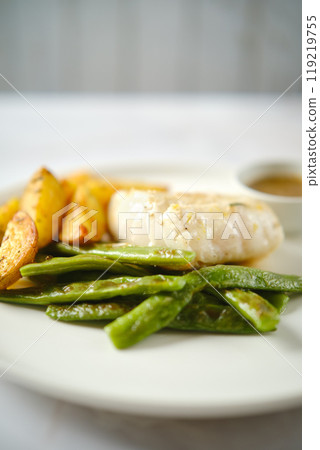 Delicious plated fish fillet with green beans and golden roasted potatoes served in a restaurant 119219755