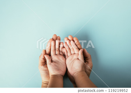 Family top view hands stacked on isolated background. Parents and kid hold empty space expressing support and love for Family and Parents Day. Family top view hands stacked on isolated background. Parents and kid hold empty space expressing support and love for Family and Parents Day. 119219952