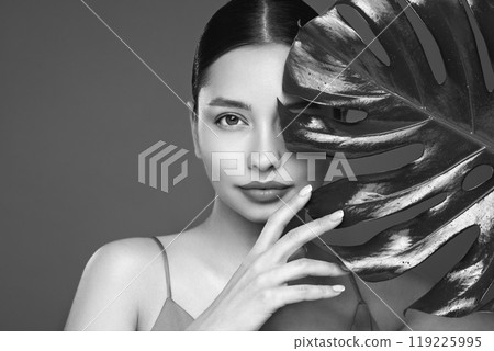 Close up woman face with green exotic leaf 119225995