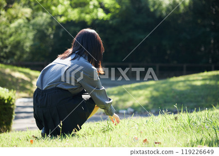一個高中女孩在夏日公園快樂地玩耍 一個高中女孩在夏日公園快樂地玩耍 119226649