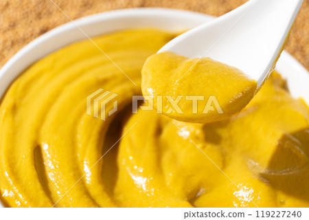 Traditional spicy mustard sauce in a spoon close-up. Traditional spicy mustard sauce in a spoon close-up. 119227240
