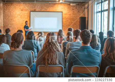 Participants concentrating on a seminar in a bright open concept classroom with modern industrial decor 119227330