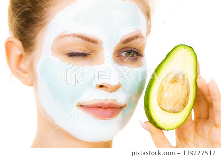 Girl facial mud mask holds avocado fruit 119227512