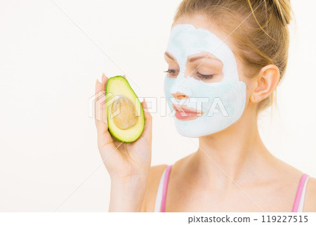 Girl facial mud mask holds avocado fruit 119227515