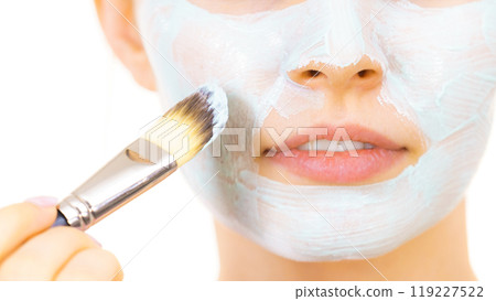 Girl apply green mud mask to face Girl apply green mud mask to face 119227522