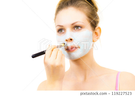 Girl apply green mud mask to face Girl apply green mud mask to face 119227523