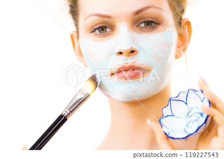 Girl apply green mud mask to face Girl apply green mud mask to face 119227543