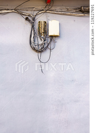 Cable power cords in tangled mess on wall outdoor Cable power cords in tangled mess on wall outdoor 119227691