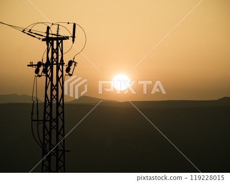 High voltage towers on coast at sunset 119228015