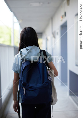 A junior high school student walking to school in the hallway of an apartment building on an autumn morning 119228328