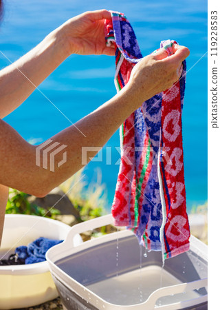 Female washing laundry on holidays trip. 119228583