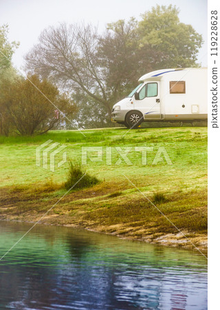 Camper rv camping at lake shore. Foggy day Camper rv camping at lake shore. Foggy day 119228628