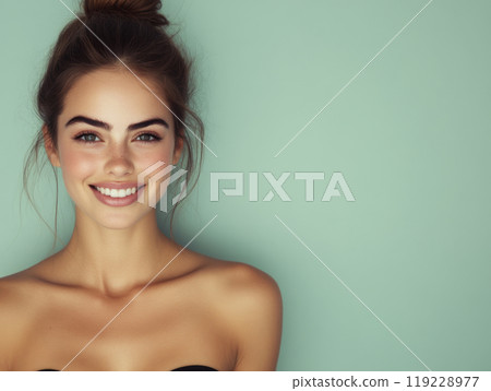 Young woman with a cheerful smile poses against a soft pastel background in natural light Young woman with a cheerful smile poses against a soft pastel background in natural light 119228977