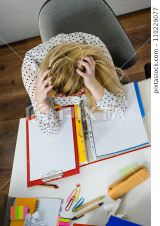 Depressed businesswoman sitting at desk Depressed businesswoman sitting at desk 119229077