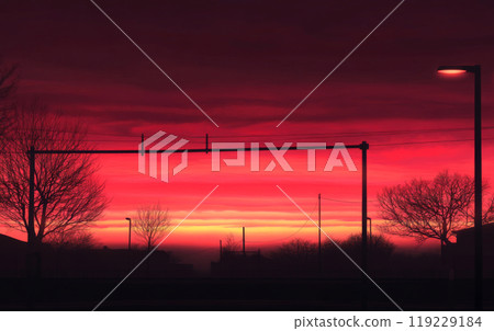 Dramatic sunset paints the sky with vibrant colors over a quiet urban landscape 119229184