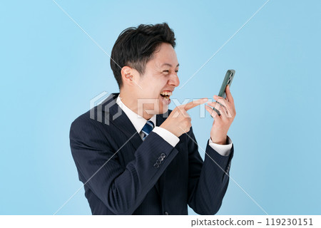 Businessman laughing with a smartphone 119230151
