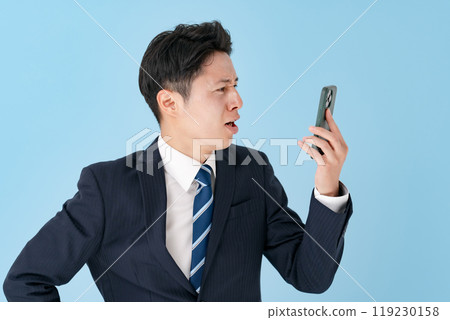A businessman having trouble holding a smartphone 119230158
