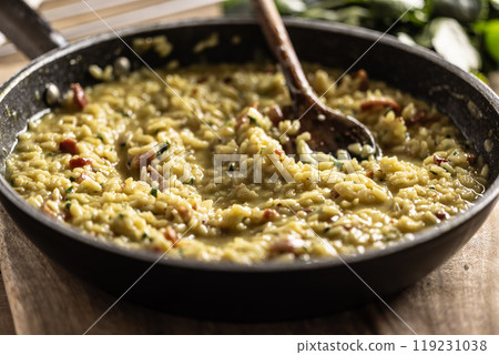 Italian risotto with pancetta, parmesan and parsley in a pan 119231038