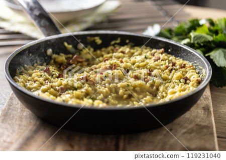 Italian risotto with pancetta, parmesan and parsley in a pan Italian risotto with pancetta, parmesan and parsley in a pan 119231040