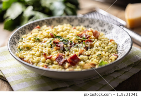 Italian risotto with pancetta, parmesan and parsley on a stylish plate 119231041