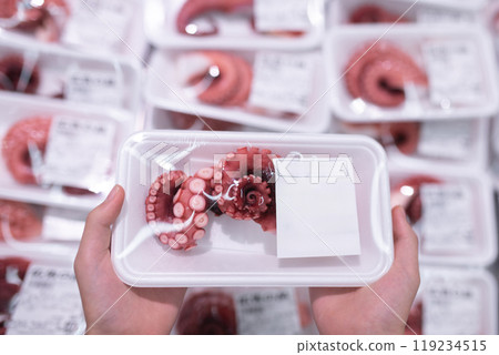 Child's hand holding a package of octopus Child's hand holding a package of octopus 119234515