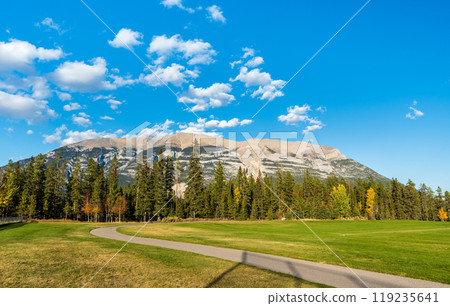 Three Sisters Sports Complex Multi-use Field & Playground. Canmore, Alberta, Canada. Canadian Rockies mountain range over the blue sky in the background. 119235641