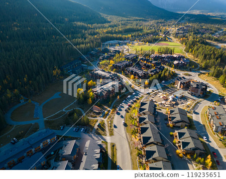 Aerial view of Town of Canmore residential area in a autumn sunny day. Canadian Rockies mountain range in the background. Alberta, Canada. Aerial view of Town of Canmore residential area in a autumn sunny day. Canadian Rockies mountain range in the background. Alberta, Canada. 119235651