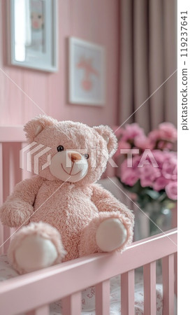 Teddy bear sitting on a cot in a pink bedroom for baby girl 119237641