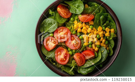 Fresh salad with spinach, tomatoes, corn and peas on green background 119238015