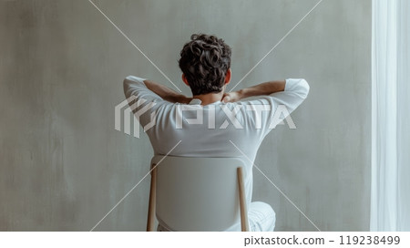 Stressed man in office chair stretches to relieve back and neck pain from computer work. Shows importance of breaks and good posture for health 119238499