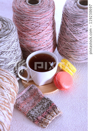 Wool yarn for knitting. A cup of coffee. Skeins of yarn for knitting as a background. Handmade work. The concept of a hobby. Vertical photo. Wool yarn for knitting. A cup of coffee. Skeins of yarn for knitting as a background. Handmade work. The concept of a hobby. Vertical photo. 119238697
