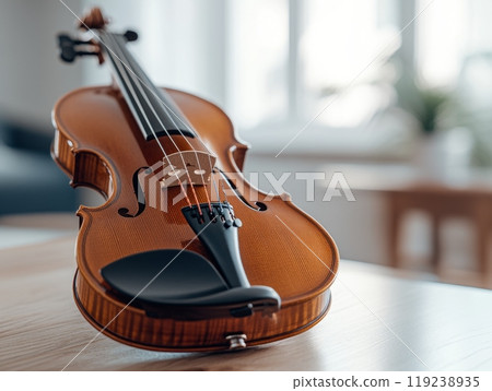 Beautiful violin lying on a table in a bright room 119238935