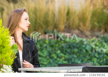 Woman waiting in outdoor restaurant cafe. 119239191