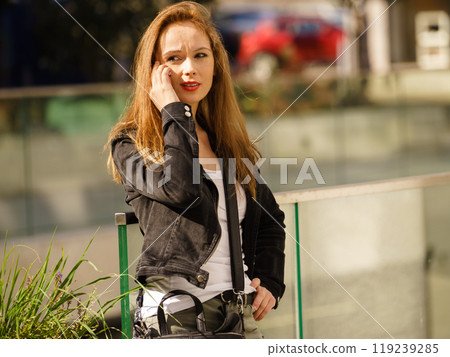 Fashionable woman using phone outdoor 119239285