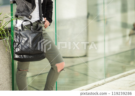Woman in green trousers with holes on knees 119239286