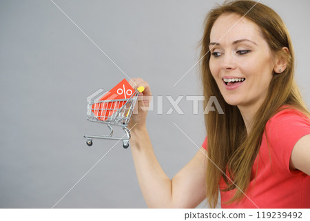 Girl with shopping cart and sale tag. 119239492