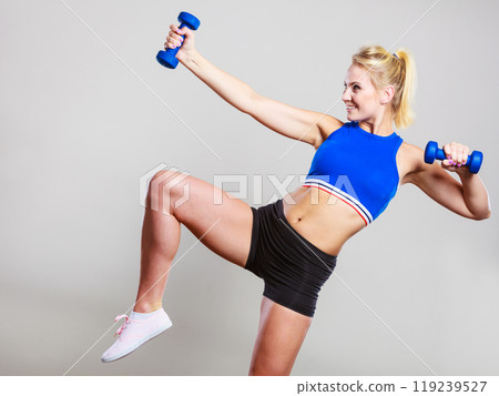 Fit woman lifting dumbbells weights 119239527