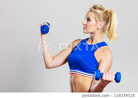 Fit woman lifting dumbbells weights 119239528