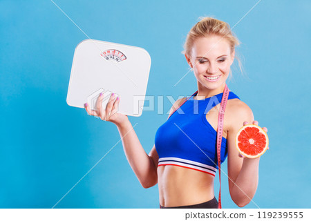 Fit woman holds weight scale grapefruit Fit woman holds weight scale grapefruit 119239555