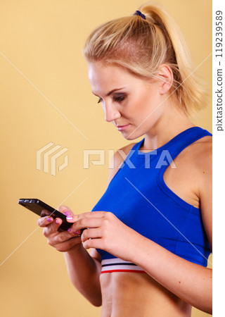 Sportswoman using mobile phone in the gym. 119239589