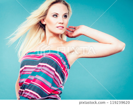 Blonde woman wearing colorful striped strapless shirt Blonde woman wearing colorful striped strapless shirt 119239620