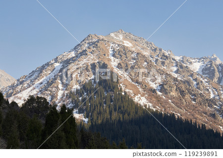 High rocky mountain with snow, illuminated by the warm setting sun High rocky mountain with snow, illuminated by the warm setting sun 119239891