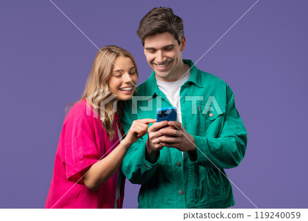 Young Couple Using Mobile Device. Woman Man Watching, Laughing With Smartphone Young Couple Using Mobile Device. Woman Man Watching, Laughing With Smartphone 119240059