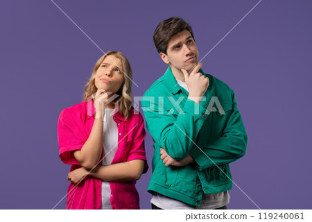 Curious young couple analyzing on violet studio. Mindful man woman searching solution, finding answer. Memory concept Curious young couple analyzing on violet studio. Mindful man woman searching solution, finding answer. Memory concept 119240061