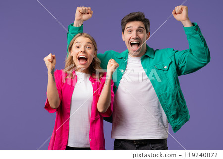 Pretty woman and man shows triumph yes yeah, hooray gesture of victory, achieved result, goals. Stylish couple glad, happy, surprised excited on violet background. Pretty woman and man shows triumph yes yeah, hooray gesture of victory, achieved result, goals. Stylish couple glad, happy, surprised excited on violet background. 119240072