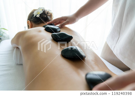 Hot stone massage at spa salon in luxury resort. Quiescent 119240398